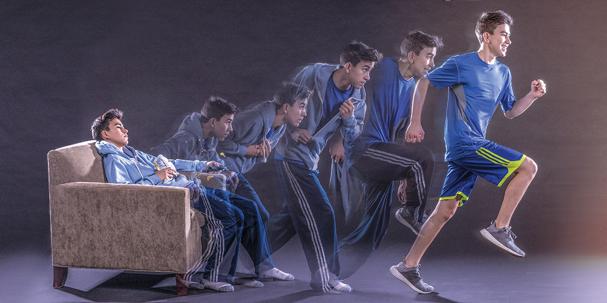 一个窝在沙发上的男孩站起来开始跑步