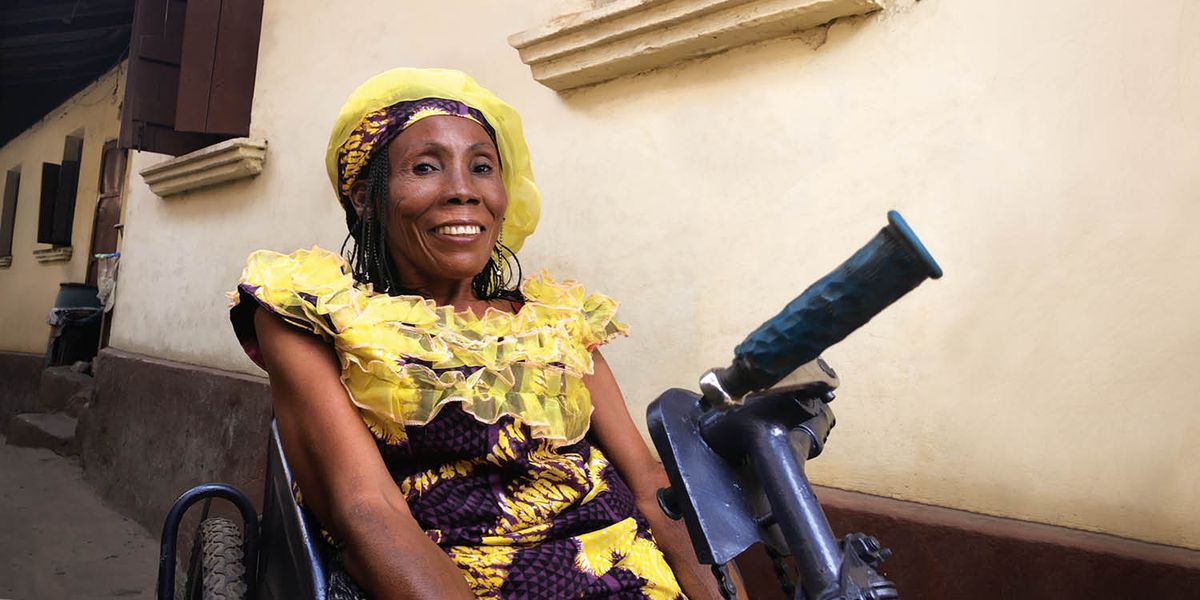 洁依·坎贝尔坐在三轮车上，满脸笑容。