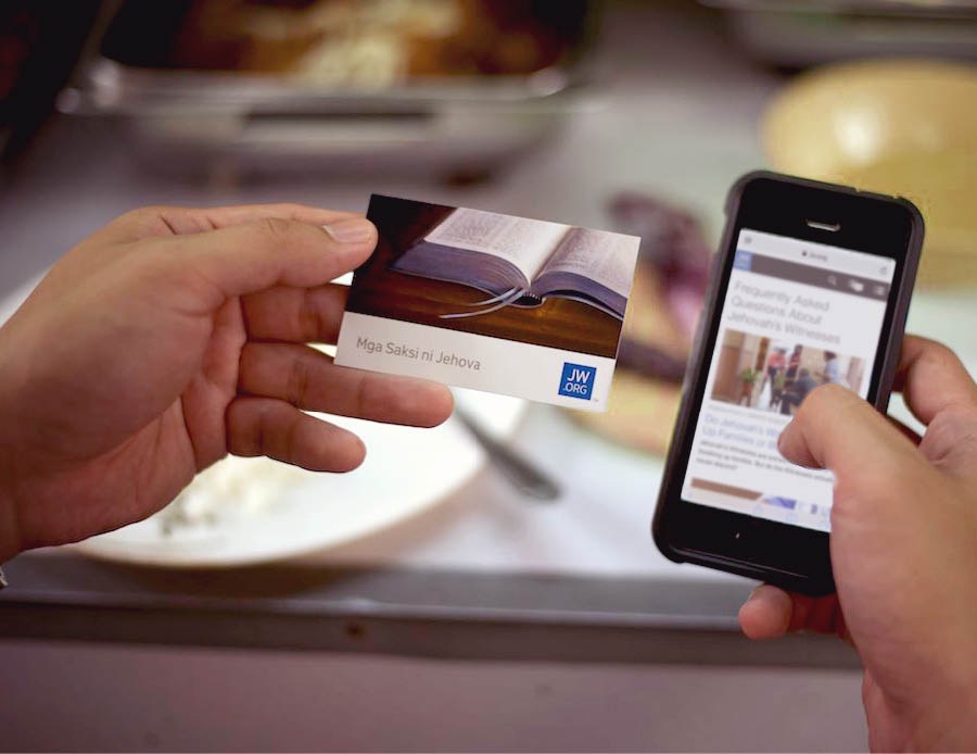 弟兄用见证卡向一个男子介绍jw.org