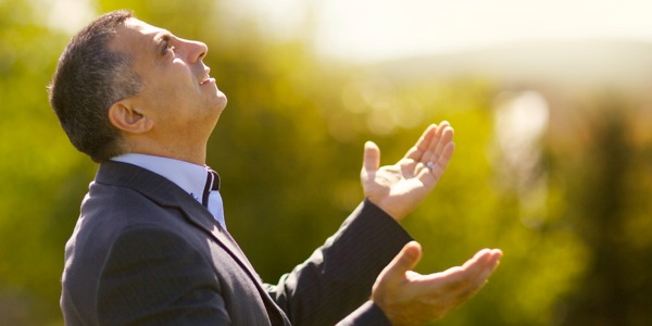 一个男子张开双手仰天向上帝祷告