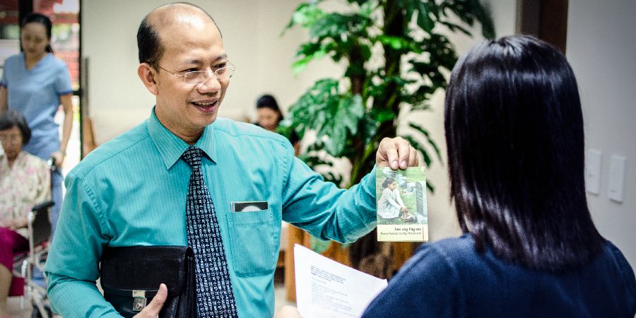 在菲律宾，乔纳森给在医院柜台工作的女子传单