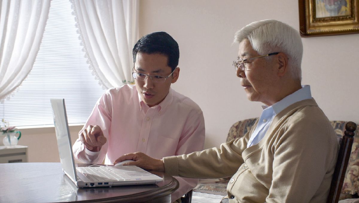 A young brother helps an older brother donate electronically