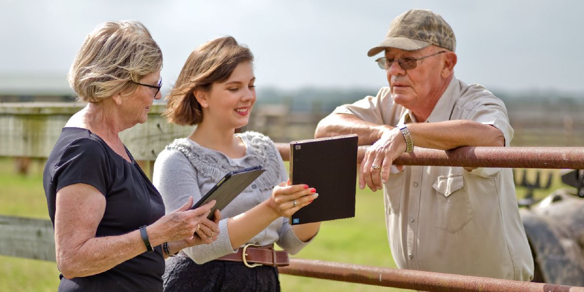 Two sisters using their tablets to preach to a rancher.