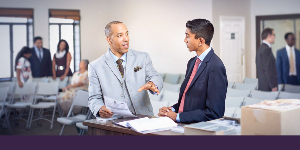 An elder talks with a young brother as he trains him to serve in the congregation