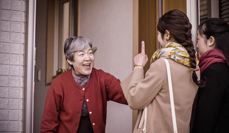 The pioneer and another sister greeting a Bible student as they arrive at her home to study the Bible with her.