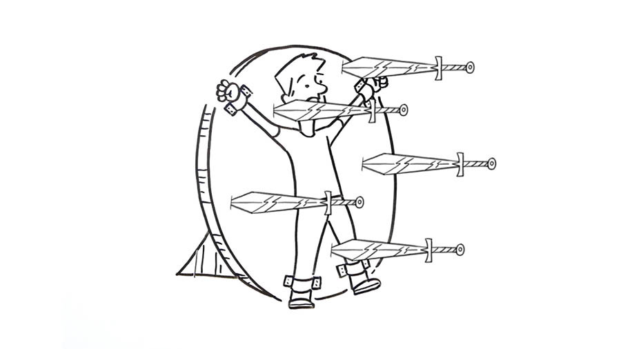 A boy tied to a circular target board with knives penetrating the board all around him.