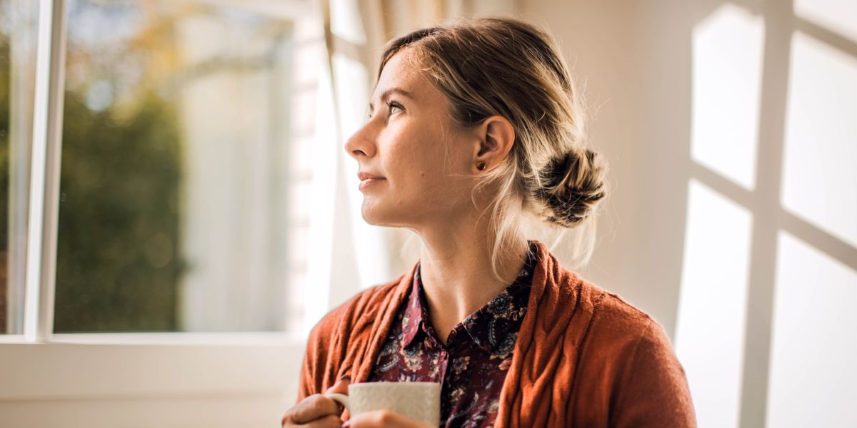 A sister gazing contentedly out a window.