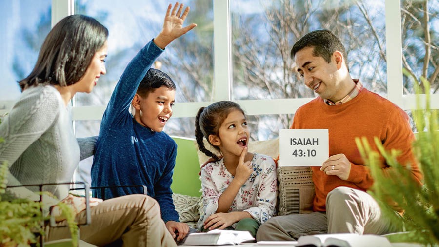 During family worship, parents use flash cards to help their children memorize scriptures
